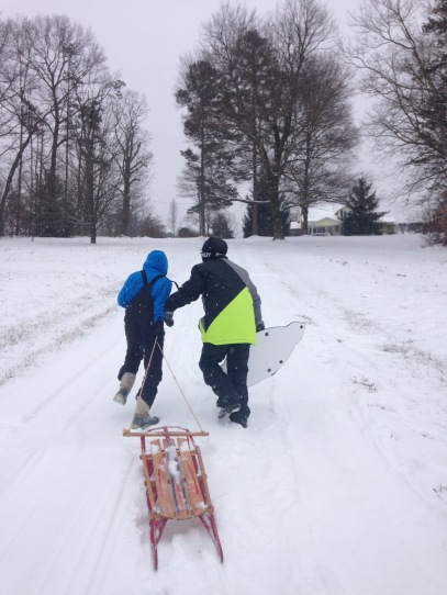 Grant and his friend Kiran sled in the snow